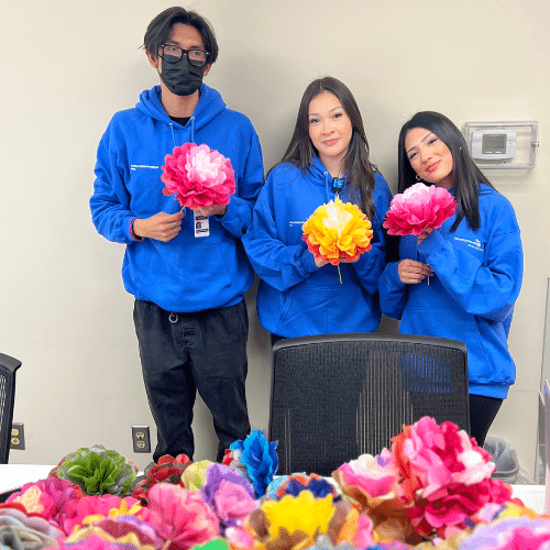 Three volunteer interns with flowers