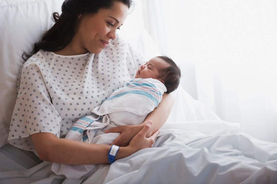 Woman holding newborn in hospital