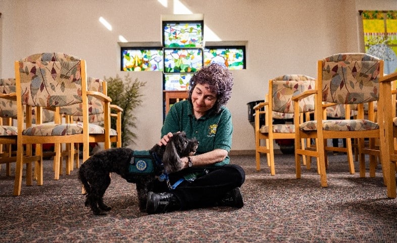 A woman pets a dog.