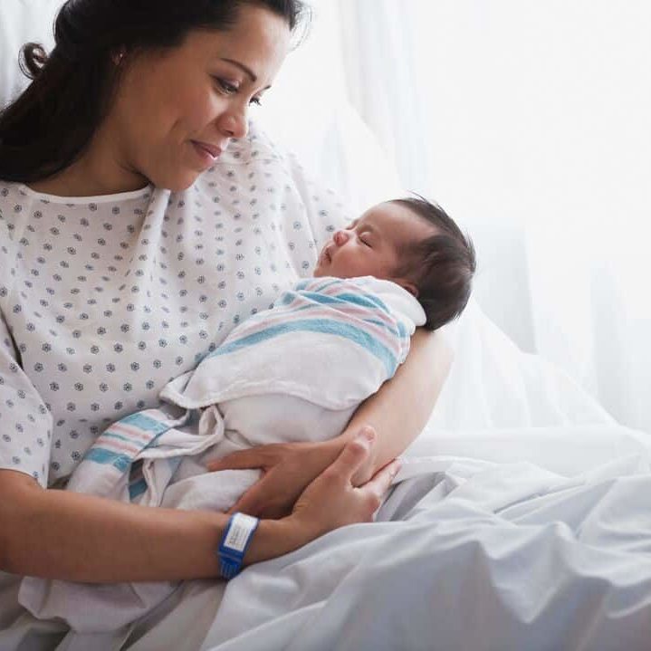 Woman holding newborn in hospital